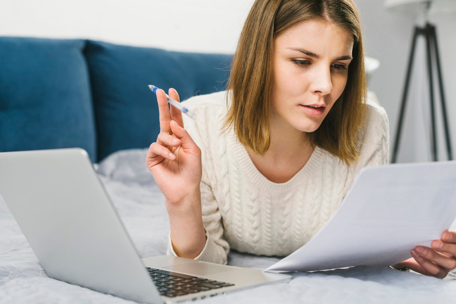 young-woman-reading-documents-bed